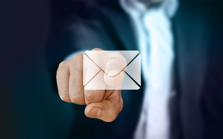 Image of a businessman pointing to an email emoticon.