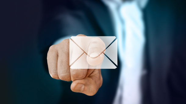 Image of a businessman pointing to an email emoticon.